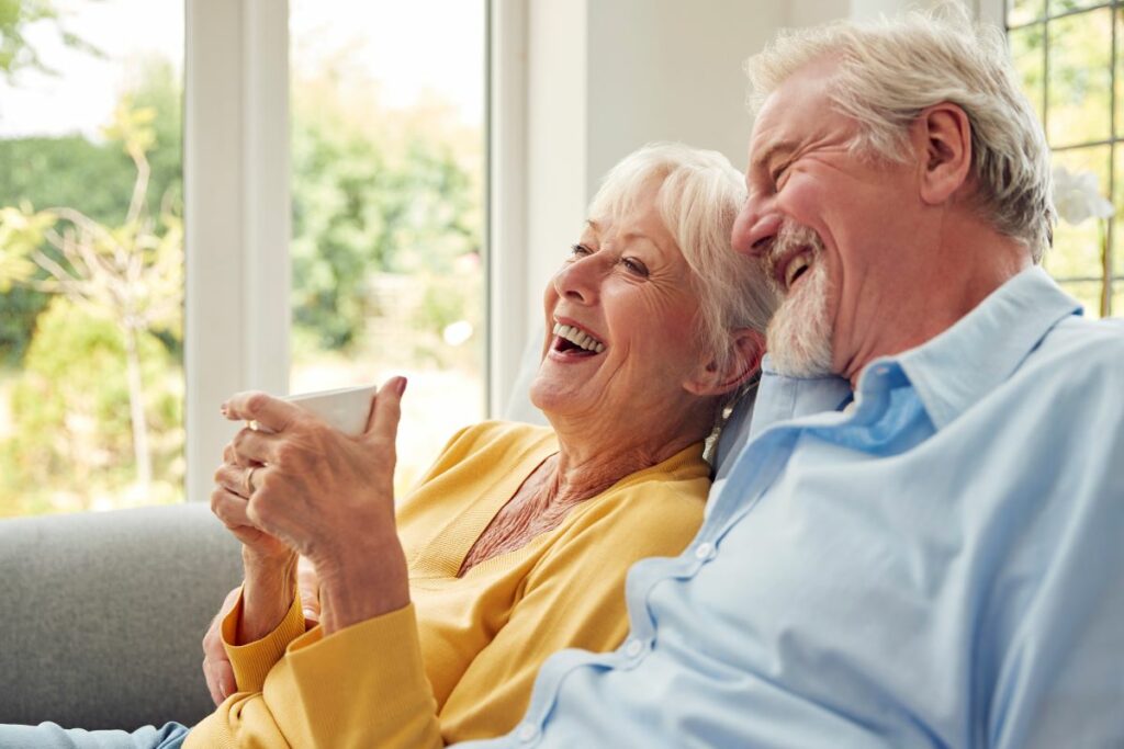 Two seniors laughing and reviewing tips to senior living care level