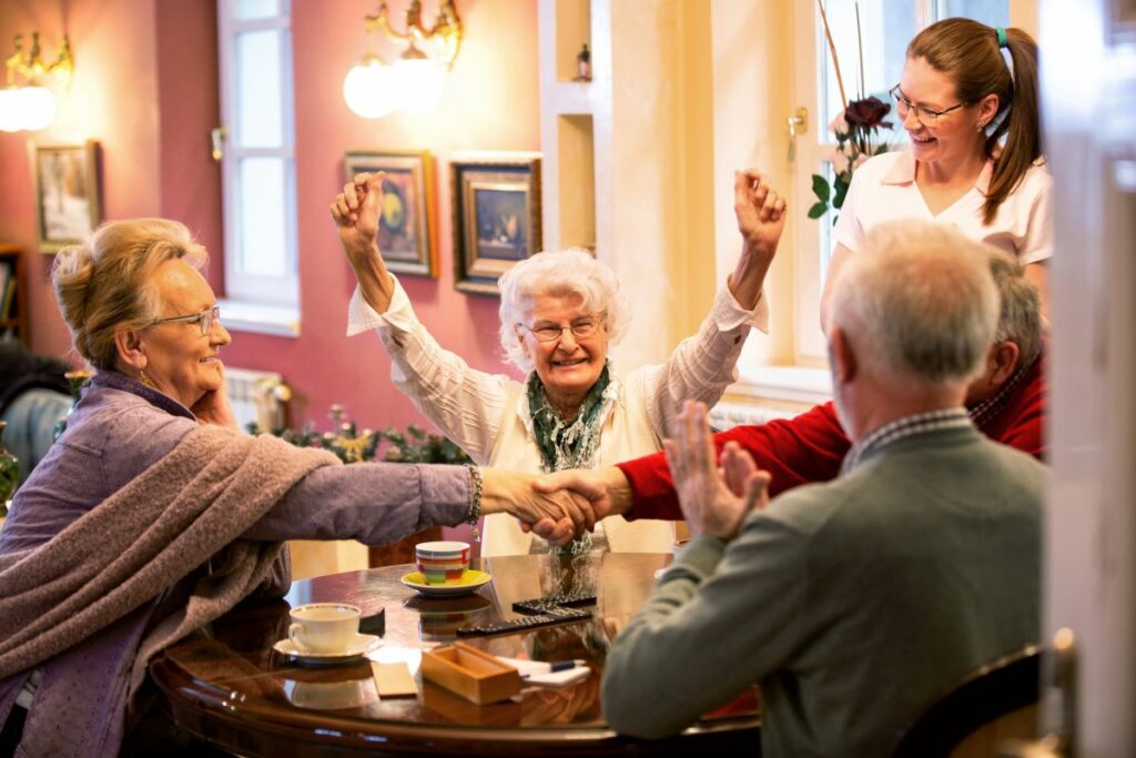 Seniors around table socializing navigating memory Care